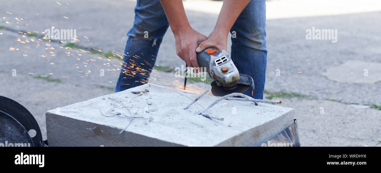 Frau trennt, Metall mit einer Trennscheibe. Einhand Winkelschleifer. Flex von Beton Stockfoto