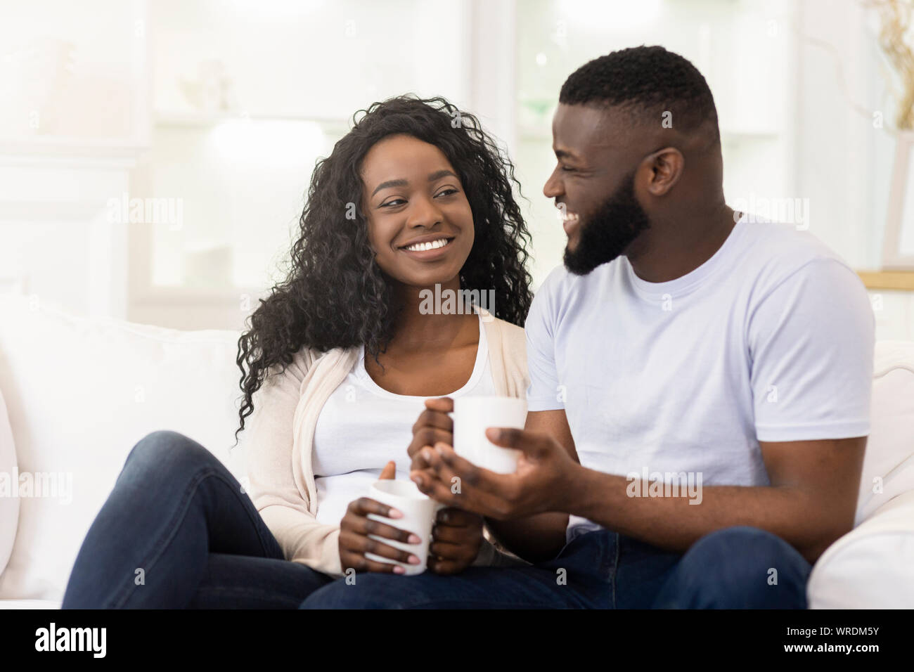 Liebevolle tausendjährigen Paar entspannende mit Tasse Kaffee zu Hause Stockfoto