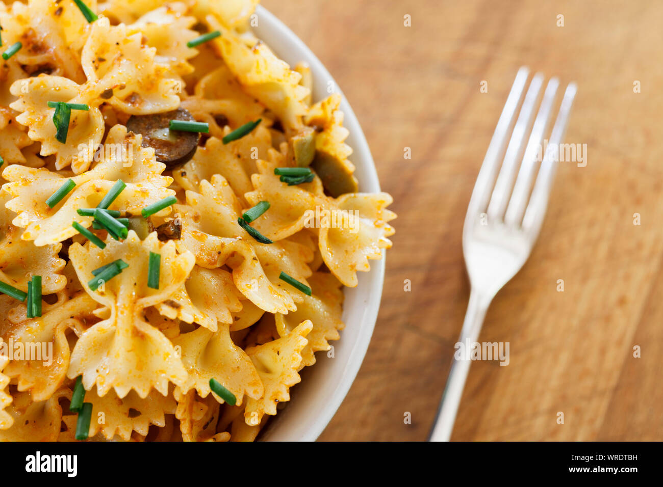 Schale gekochte Farfalle Pasta oder Bow-tie Pasta in frischem Pesto mit gehackten Schnittlauch, Nahaufnahme Stockfoto