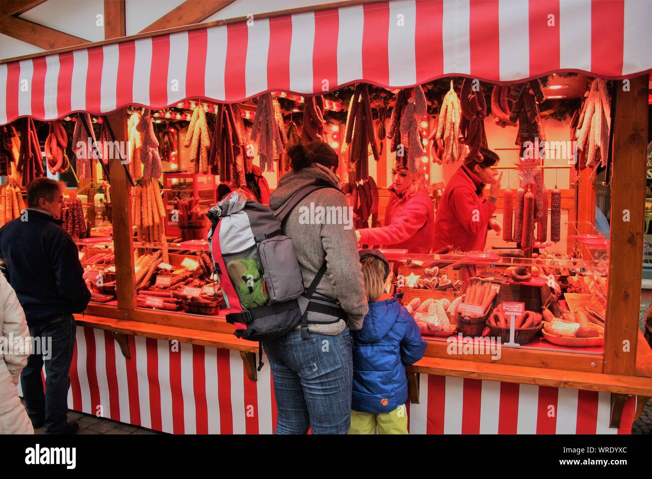 Marktstand auf einem Weihnachtsmarkt in Potsdam, Verkauf von Würstchen in allen Variationen. Käufer und Verkäufer. Deutschland, Europa. Stockfoto
