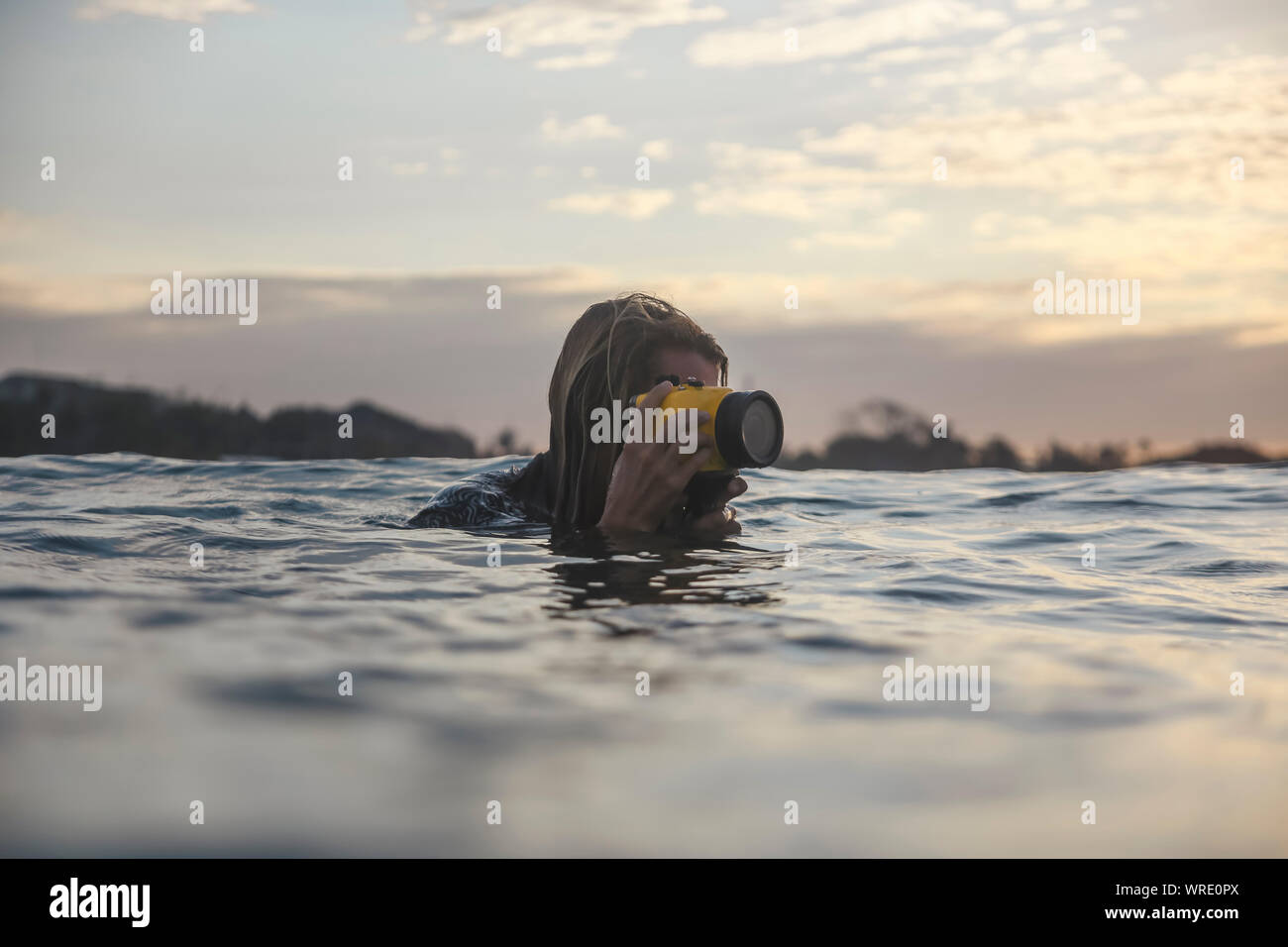 Junger Mann mit Unterwasserkamera im Ozean Stockfoto