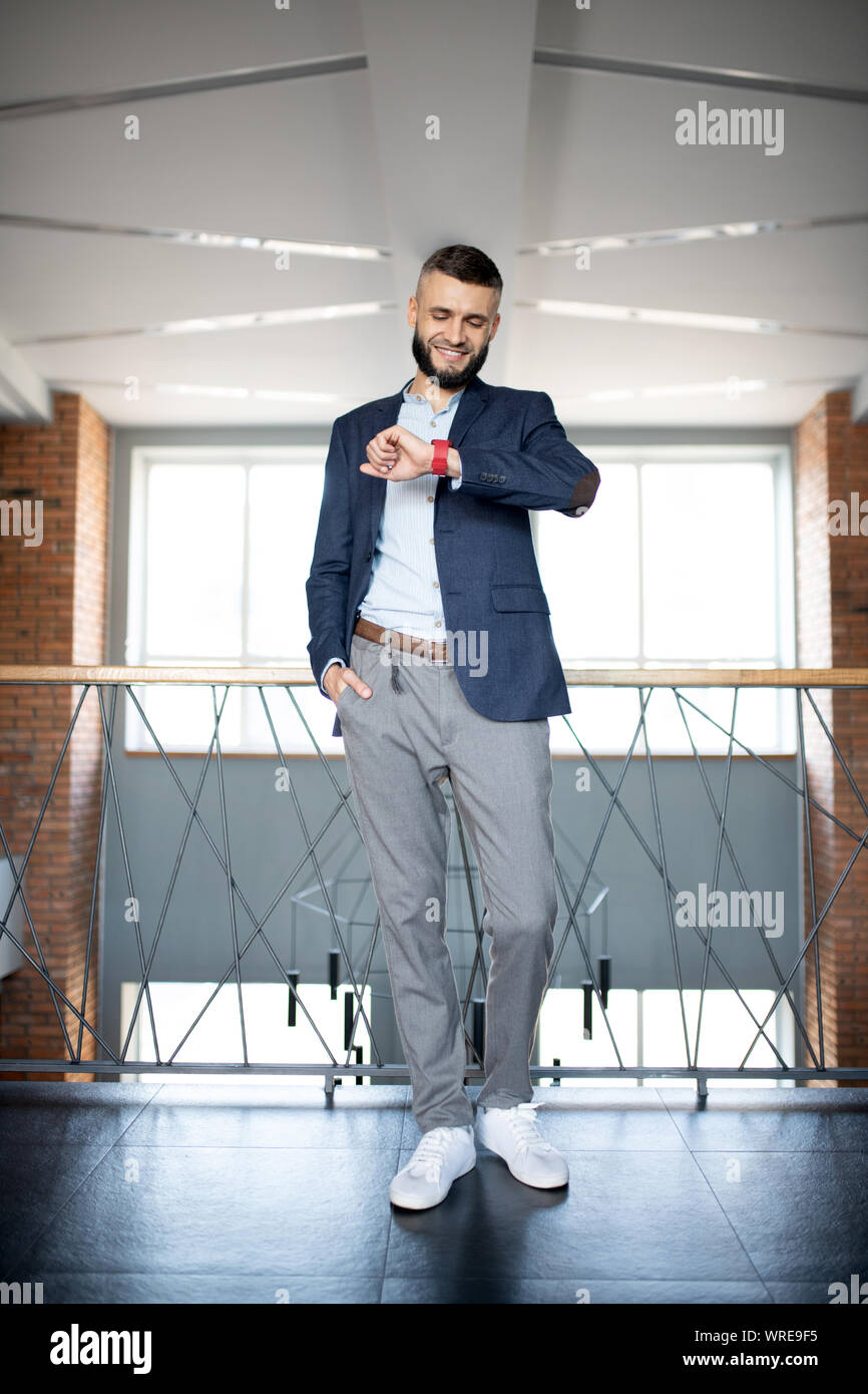 Bärtige Geschäftsmann prüfen, während spät zu treffen Stockfoto