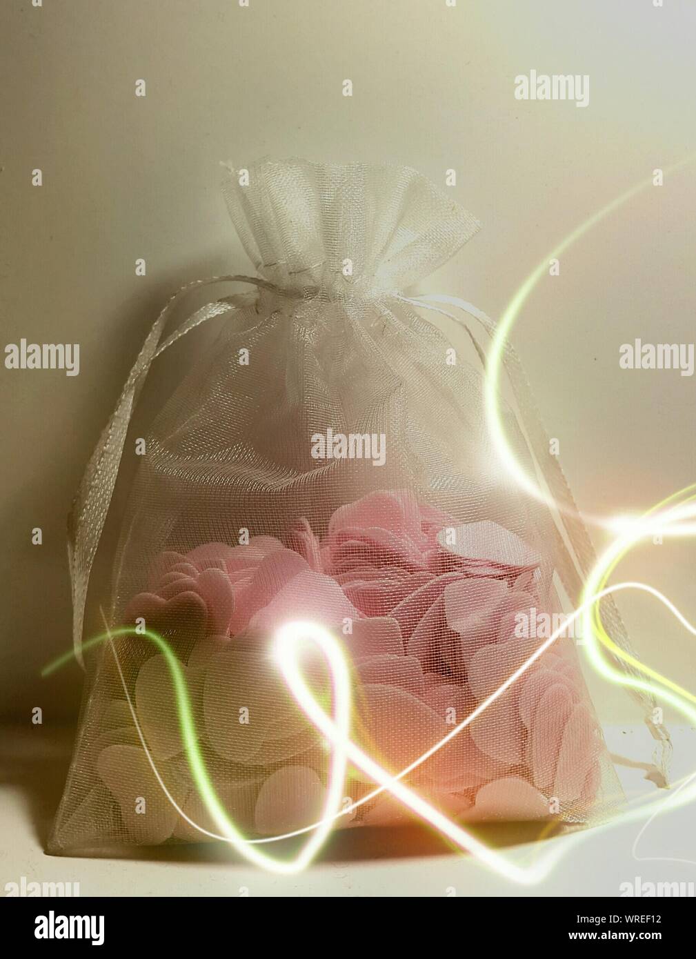 Close-up von Candy Herzen im Geschenkbeutel gegen die Wand mit Licht Trail Stockfoto