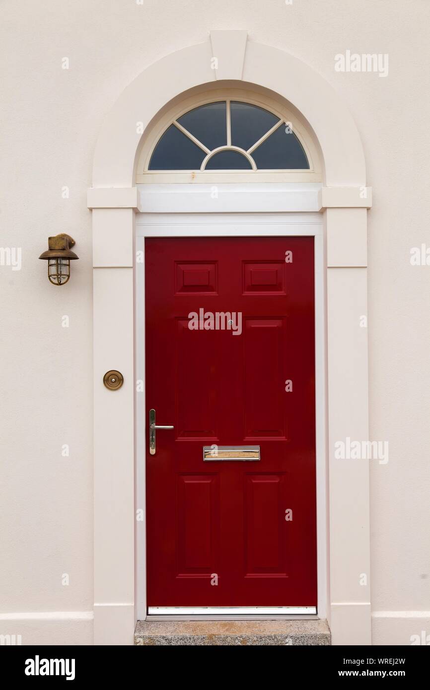 Leuchtend rote Tür, weiße Wände, draußen Licht, Stockfoto