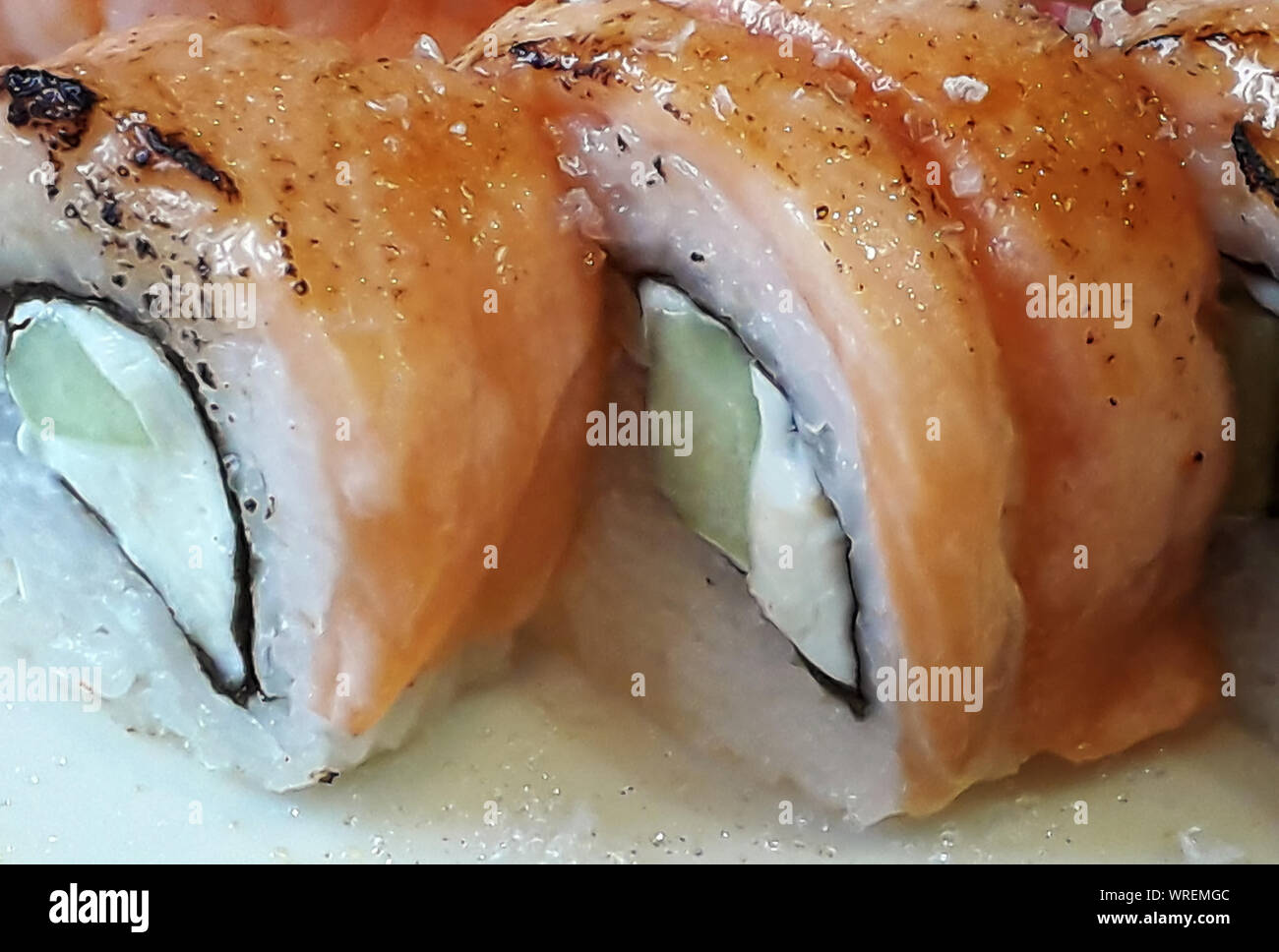 In der Nähe von paar leckere Philadelphia Walzen aus Lachs, Gurke, Reis und weicher, weißer Käse. Frische Brötchen werden auf weiße Oberfläche angeordnet. Selectiv Stockfoto