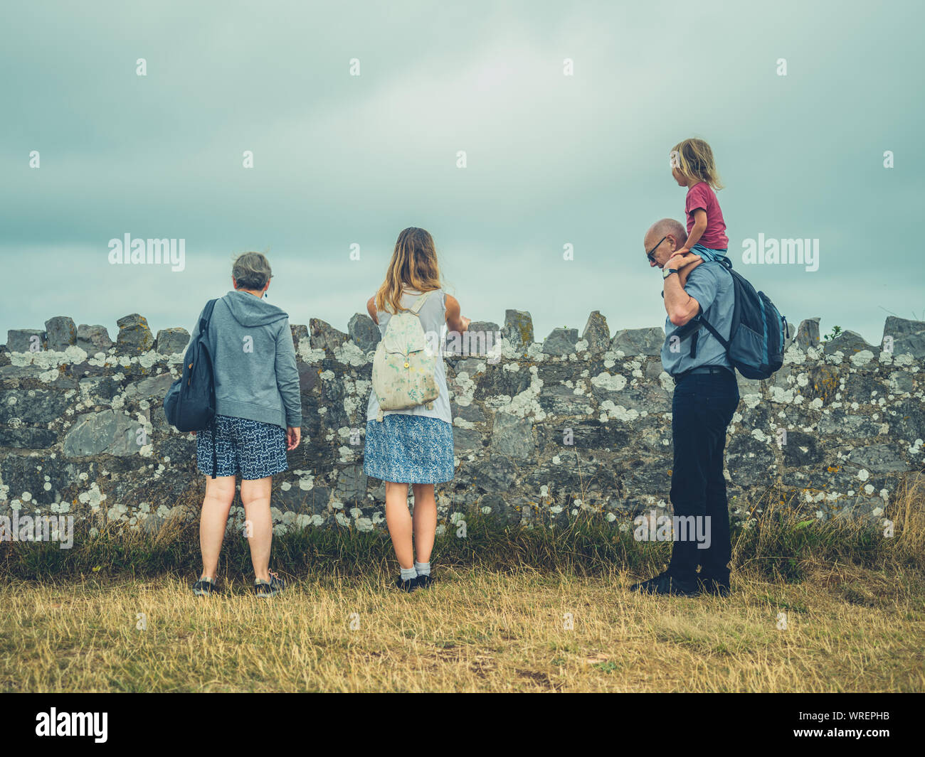 Authentische Schuß von echten Familie an der Küste in den Nebel. Junge Mutter, Kind und Großeltern. Stockfoto