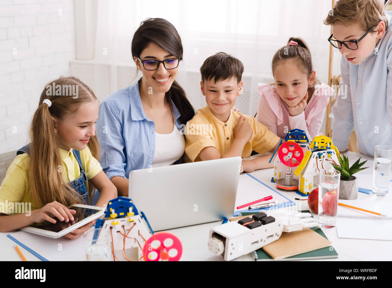 Kinder lernen über Computer und Roboter mit ihrer Lehrerin Stockfoto
