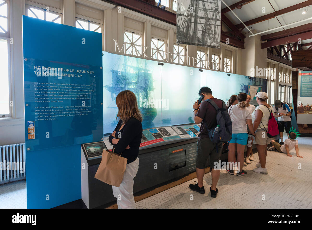 Ellis Island in New York, Blick auf die Touristen, die in der Besiedlung von Amerika Galerie in Ellis Island Immigration Museum, New York City, USA Stockfoto