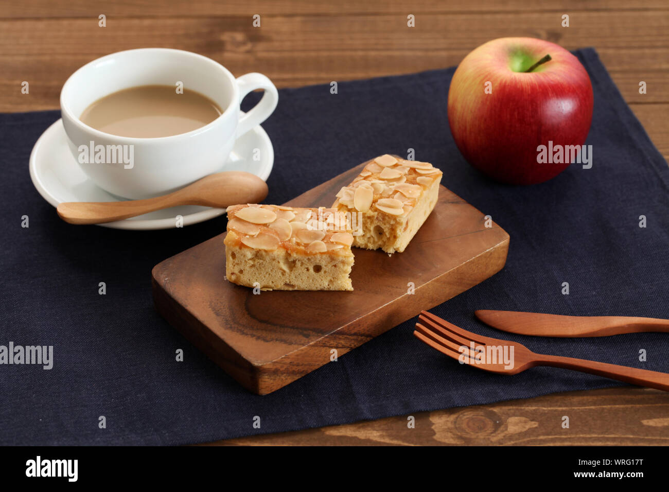 Stück Mandel Apple Pound Cake isoliert auf Schneidebrett und Milch Kaffee auf Holz Tisch Stockfoto