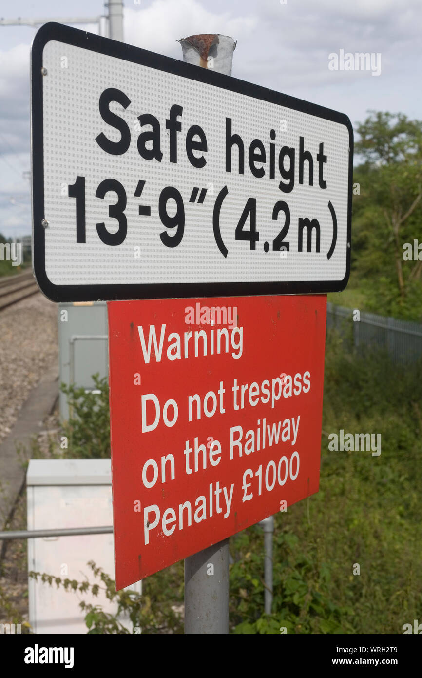 Schilder Warnung der sicheren Höhe für das Überqueren der Eisenbahnlinie und der Strafe für die Übertretung in der Nähe von Aldermaston in Berkshire Stockfoto