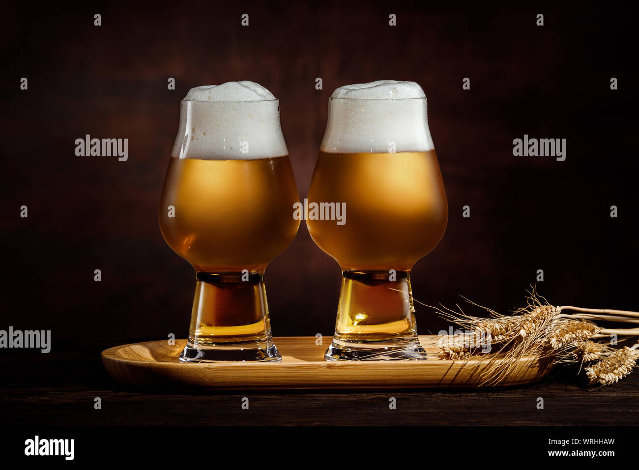 Zwei Gläser kalter golden Bier und Weizen ährchen auf dunklem Hintergrund. Stockfoto