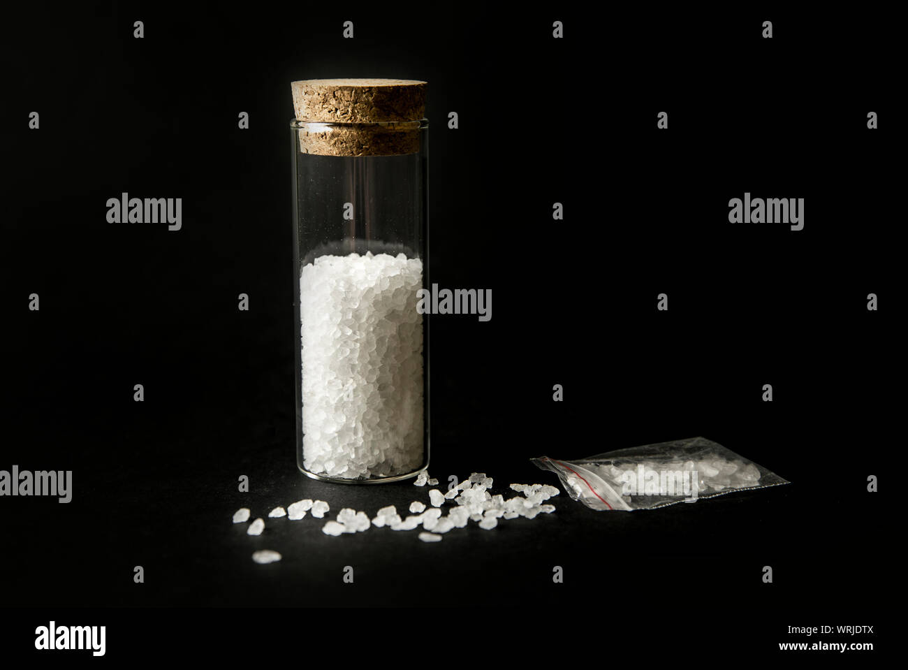 Konzeptionelle Bild von Drogen Drogen Konzept Badesalz". White Crystal Pulver auf schwarzem Hintergrund (eingerichtet), ähneln zum Badezimmer Badewanne Salz. Stockfoto