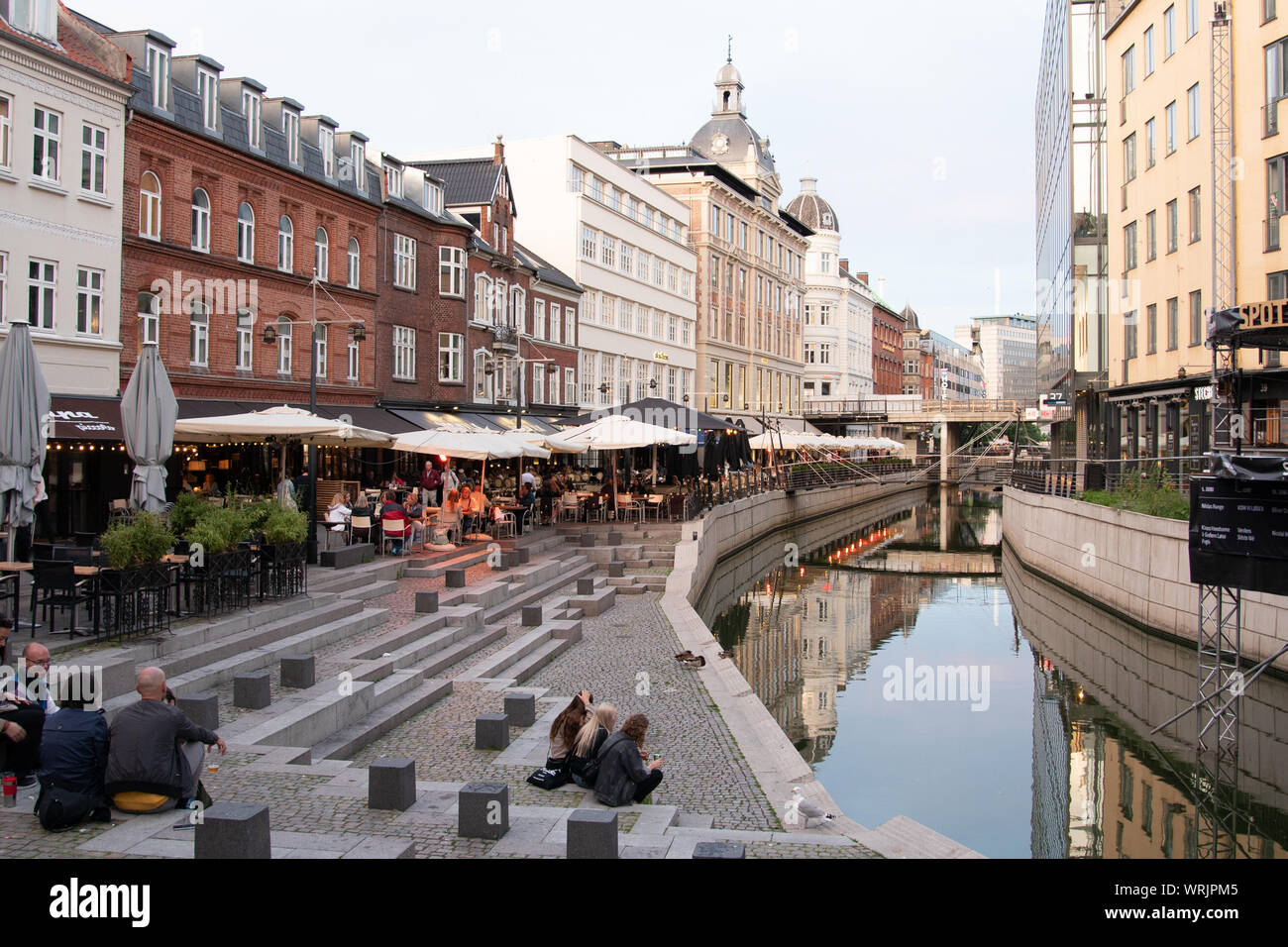 Leute sitzen auf einem Platz in Aarhus Kanal in der Mitte der Stadt, Dänemark, 15. Juli 2019 Stockfoto