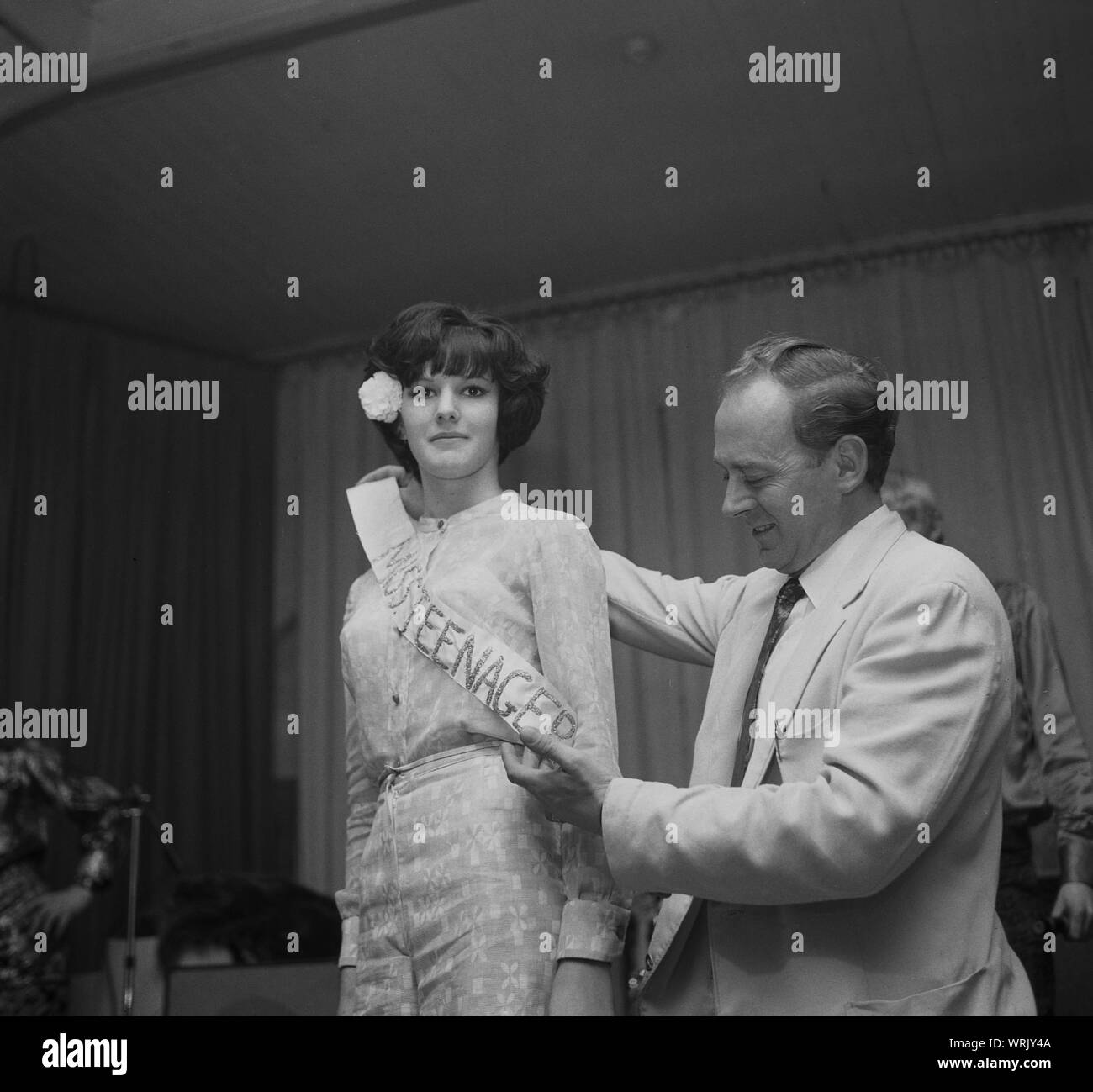 1967, historische, wining Kandidat in einem lokalen Dorf 'Miss jugendlicher Schönheit Wettbewerb, erhalten ihren Preis Anhänger, England, UK. Stockfoto