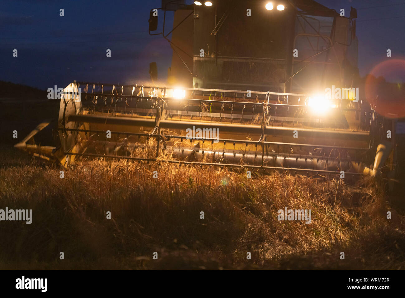 Ein Bauer arbeiten bis spät in den Abend zu beenden, eine Kombination aus einem Feld von Gerste Stockfoto