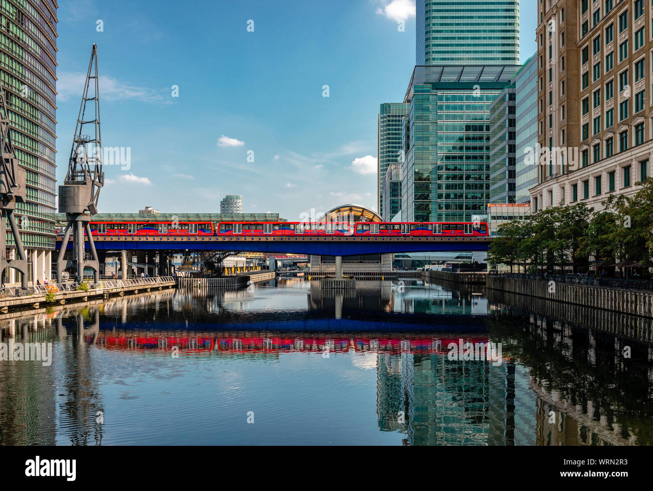 London/Großbritannien - 27. August 2019: Die Docklands Light Railway spiegelt sich auf den Gewässern des Nordens Dock, in Canary Wharf Entwicklung. Stockfoto