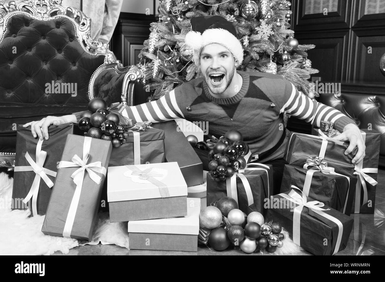 Frohes Neues Jahr und Frohe Weihnachten. Glückliche Menschen genießen das neue Jahr und die Weihnachtsfeier. Mann mit vorhanden Boxen durch Weihnachtsbaum. Die Welcome Party. Stockfoto