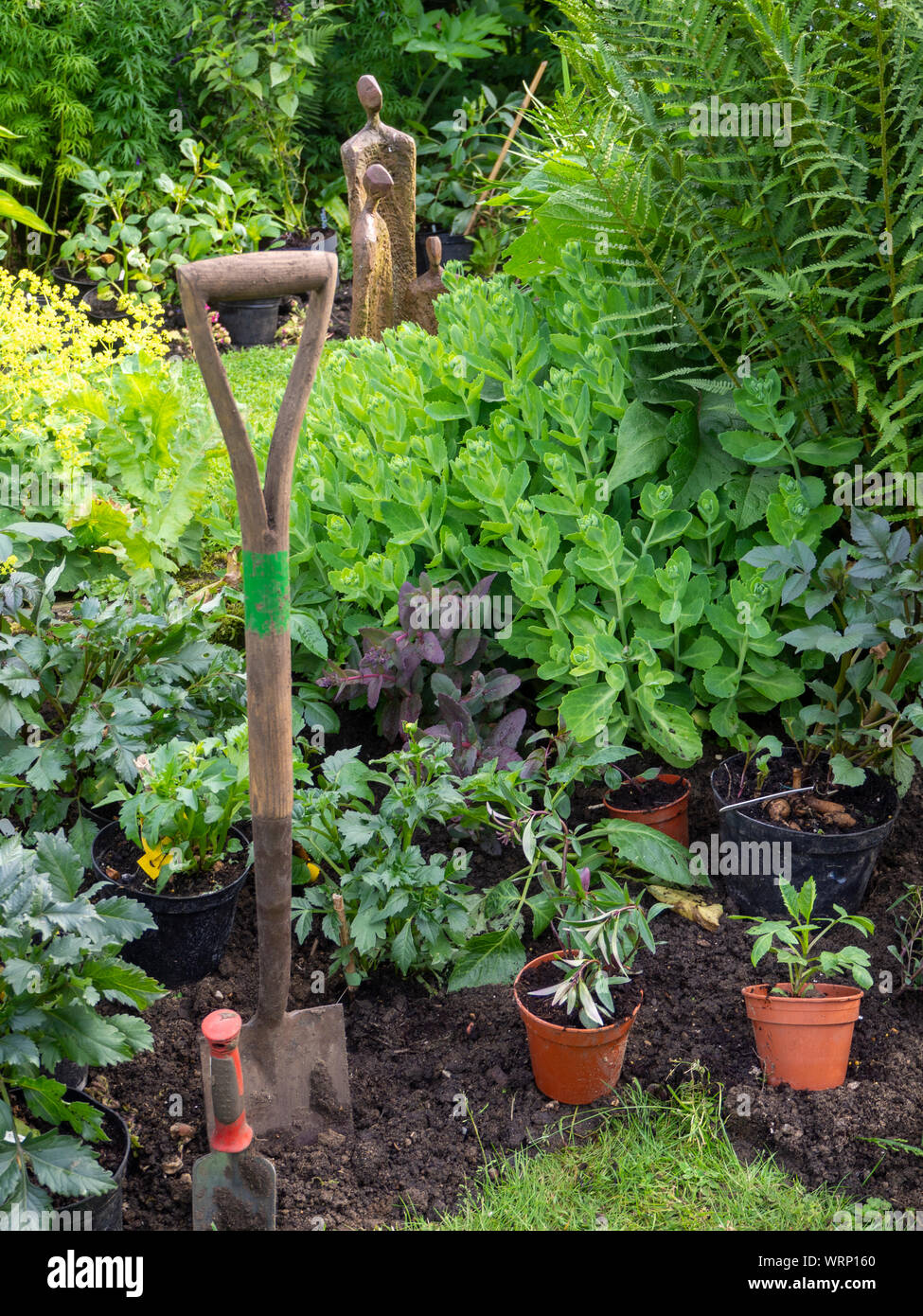 Chenies Manor Gartenarbeit in den Fortschritt. Spaten, Kelle und Blumentöpfe bereit für die dahlie Pflanzzeit vorbereiten. Stockfoto