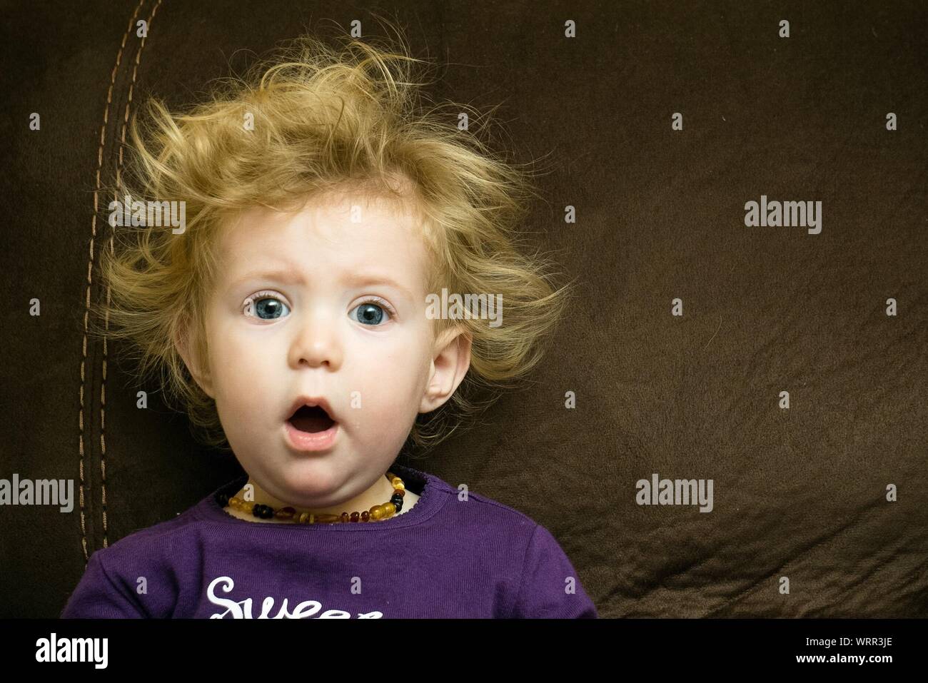 Portrait von Schockierenden niedliche Mädchen liegt auf dem Sofa Stockfoto