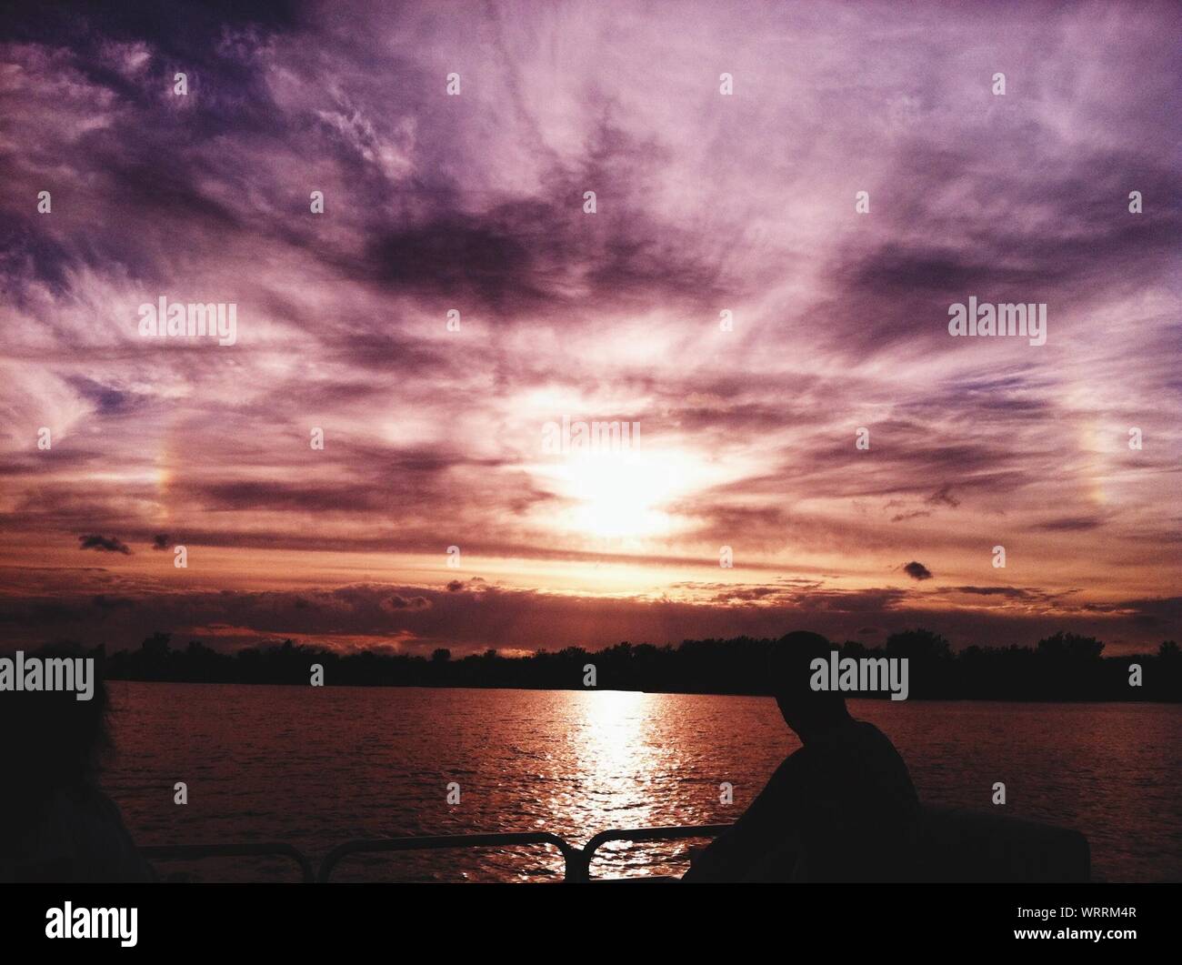 Ansicht Der Ruckseite Des Menschen Beobachten Silhouette Sonnenuntergang Von Gelander Auf See Stockfotografie Alamy