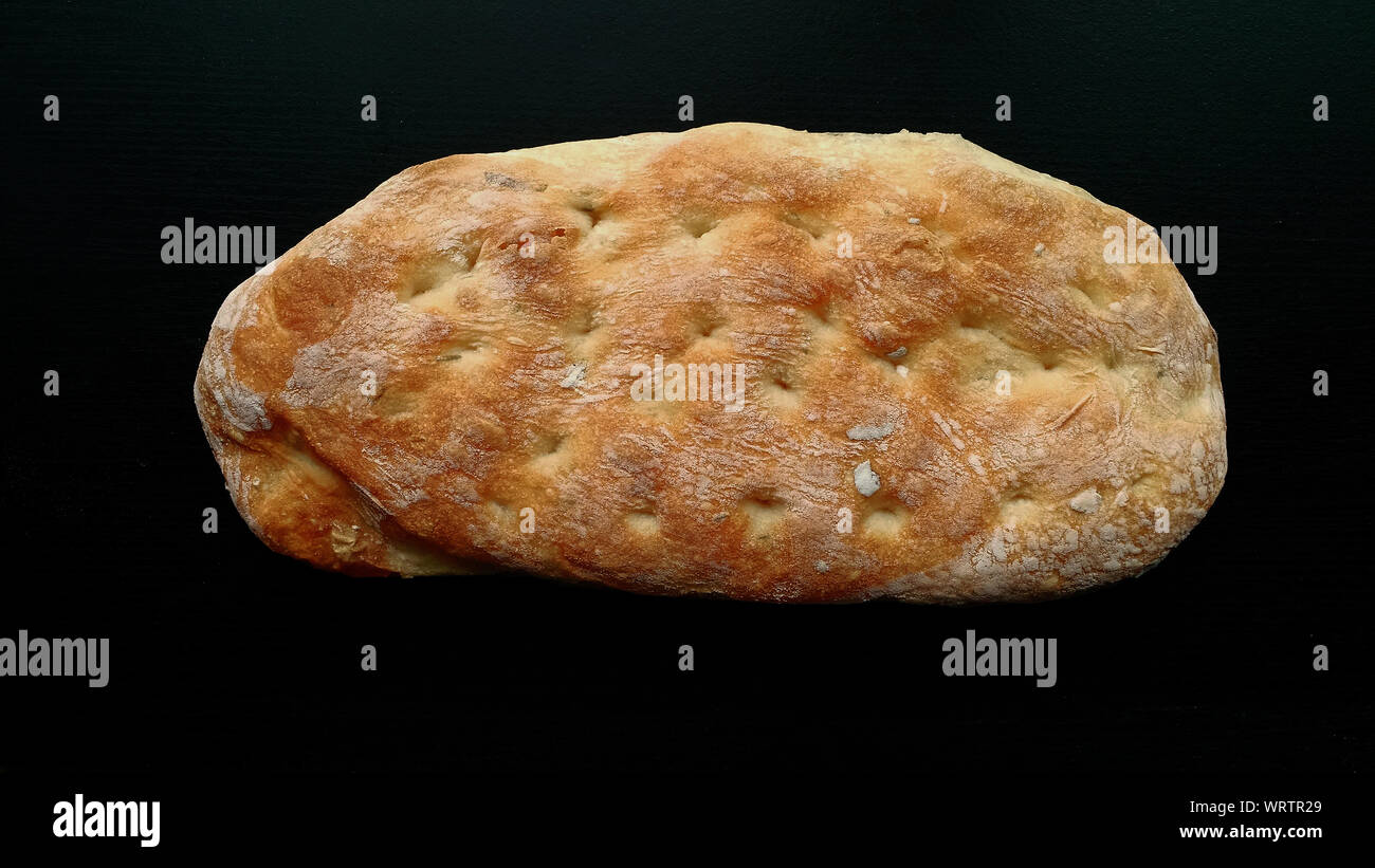 Laib Ciabatta Brot auf schwarzen Holztisch Stockfoto