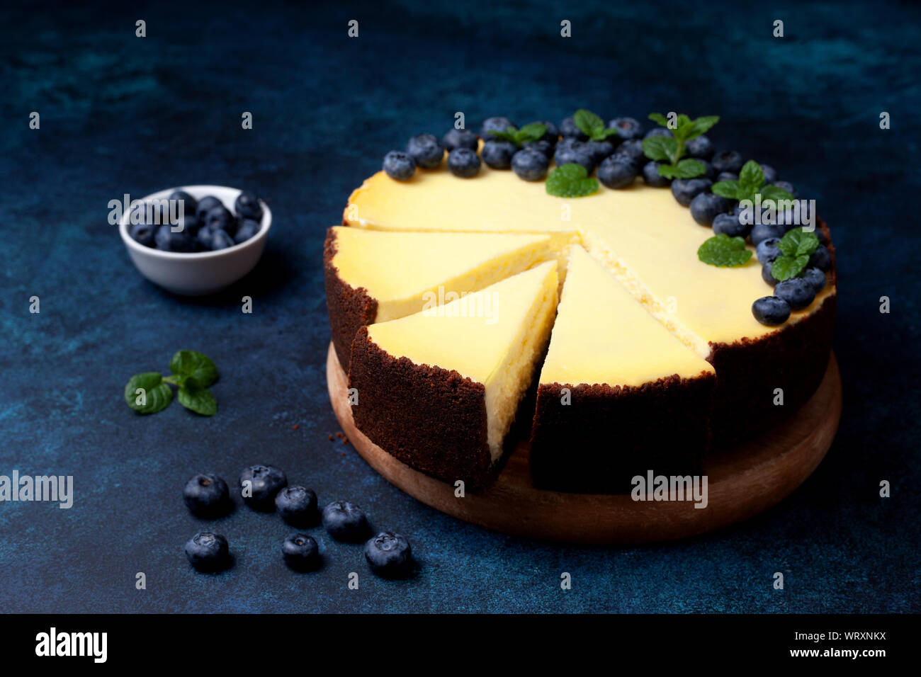 Käsekuchen mit Heidelbeeren auf blauem Hintergrund close-up Stockfoto