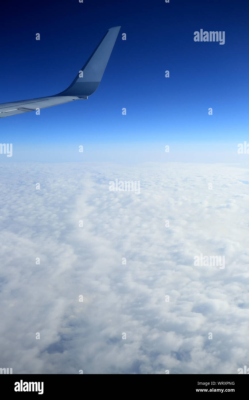 Blick auf Flugzeugflügel, Wolken im Himmel Stockfoto
