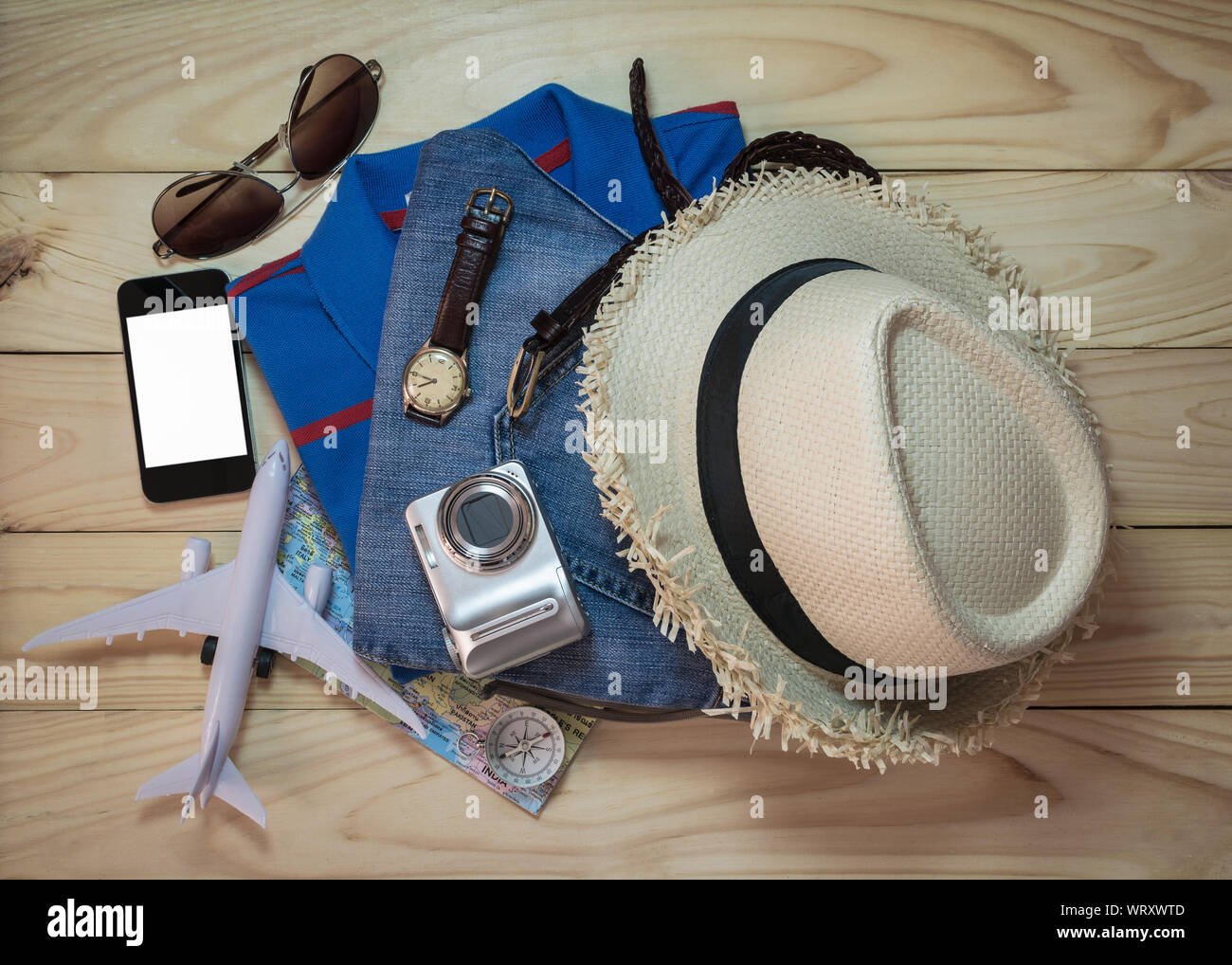 Stapel von Kleidung und Zubehör auf Holzbrett. Travel Concept. Stockfoto