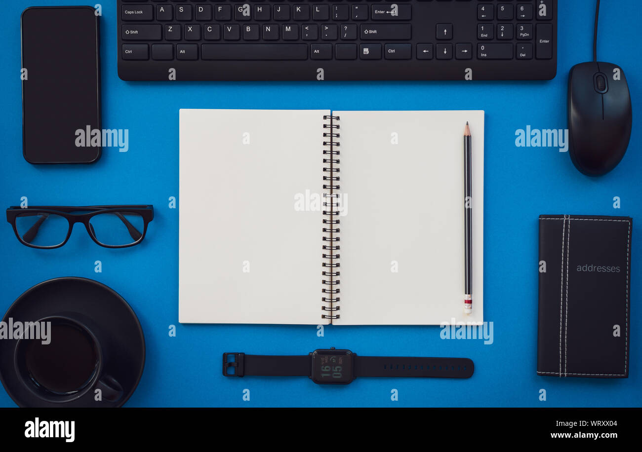 Leere weiße Notizblock mit schwarz Büro und persönliches Zubehör auf blauem Hintergrund isoliert, Business Motivation und Inspiration Konzepte. Stockfoto