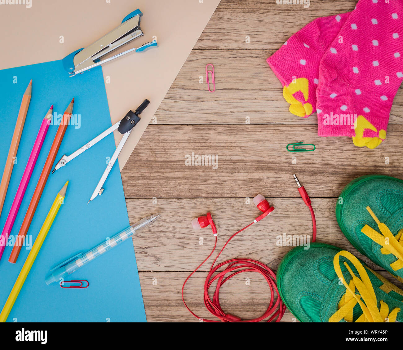 Turnschuhe, Schreibmaterial, Papier, Ohrhörer und andere auf Holzbrett, Bildung Konzept. Stockfoto