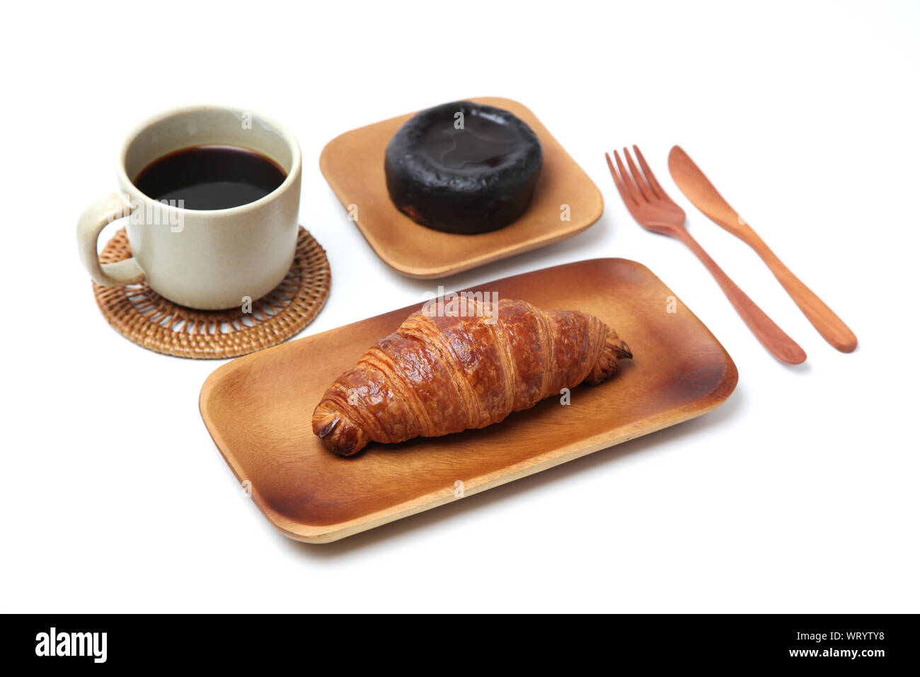 Croissant französisches Brot auf Holz Platte und heißen Kaffee mit Dessert closeup auf weißem Hintergrund Stockfoto