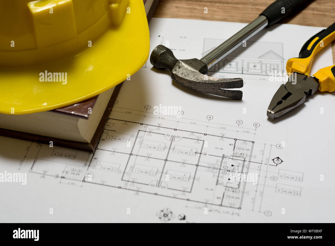 Bau plan mit Bau Helm, Buch, Hammer und Zange auf hölzernen Tisch Stockfoto