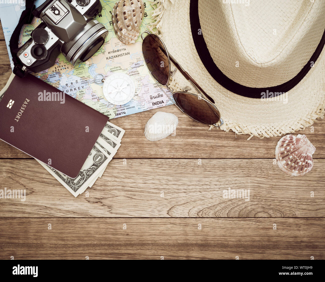 Travel Concept mit Digitalkamera, Stroh Hut, Sonnenbrille, Weltkarte, Kompass, Pass, Geld und seashell auf hölzernen Tisch Stockfoto