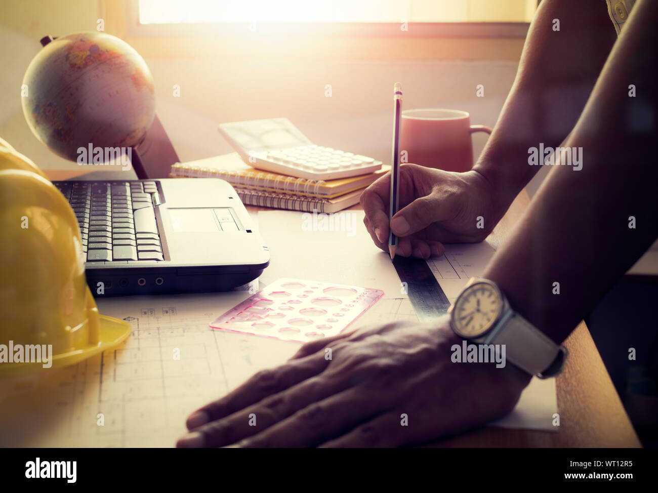 Hand des Architekten Zeichnung Bau plan auf dem Schreibtisch mit strahlend Licht, film Effekt. Stockfoto