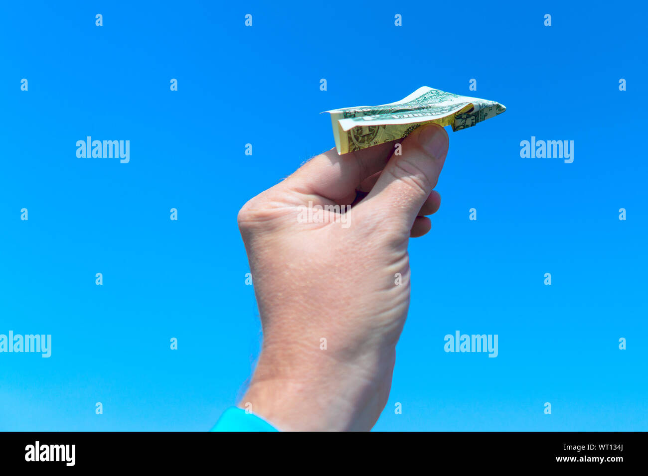 Ein Mann hält in seiner Hand ein Flugzeug aus einem dollarschein. Close-up Stockfoto