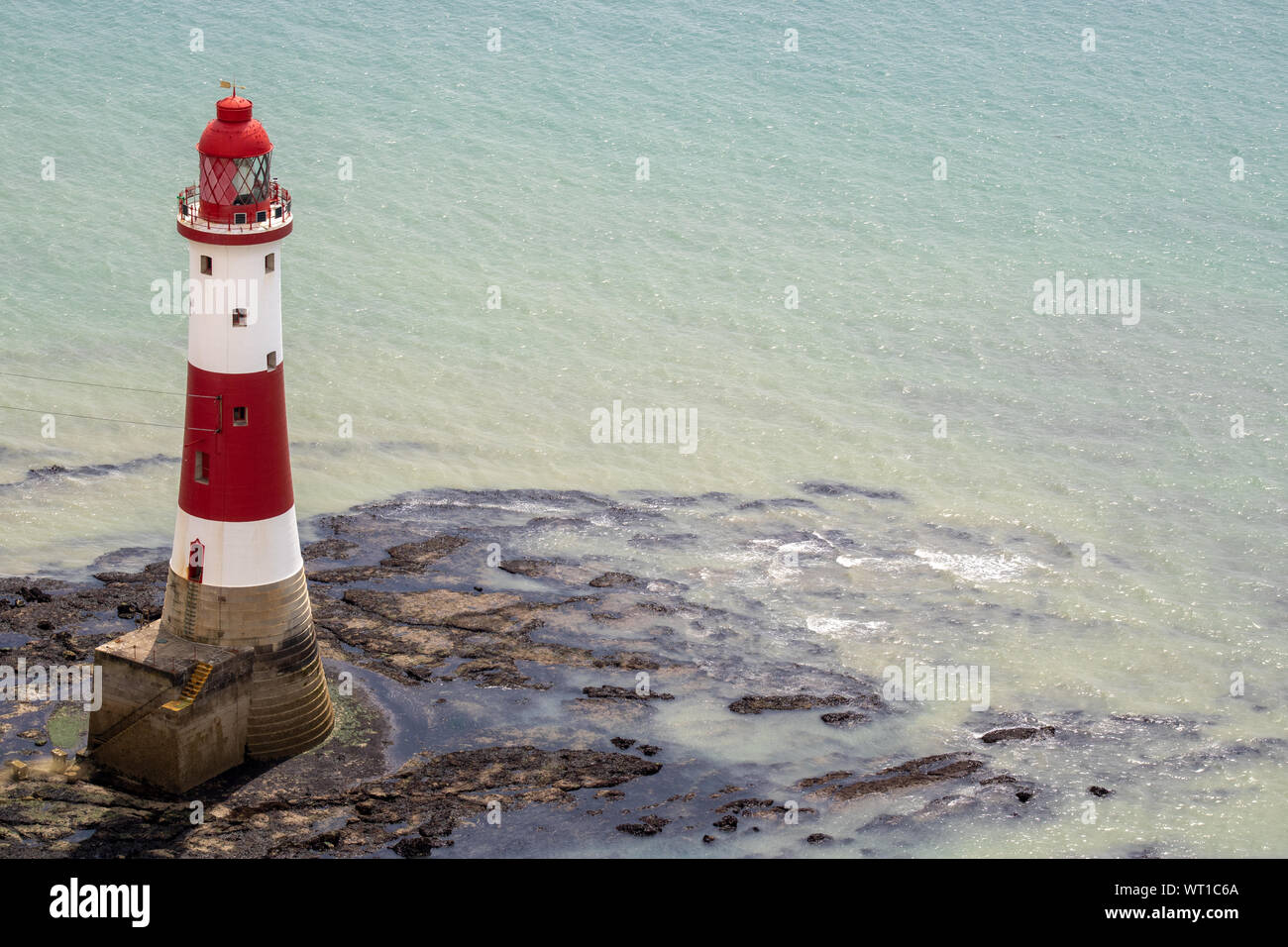 Die berühmte Beachy Head Leuchtturm auf dem felsigen Strand von Beachy Head der Chalk Landspitze Klippe in East Sussex zeigt eine typische Britische leichte Ho Stockfoto