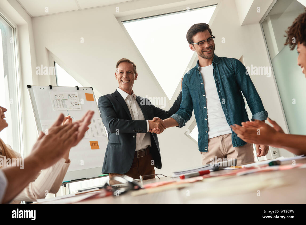 Neu im Team. Zwei freundliche Kollegen die Hände schütteln und lächelnd, während Sie an einer Konferenz im modernen Büro. Teamarbeit Stockfoto
