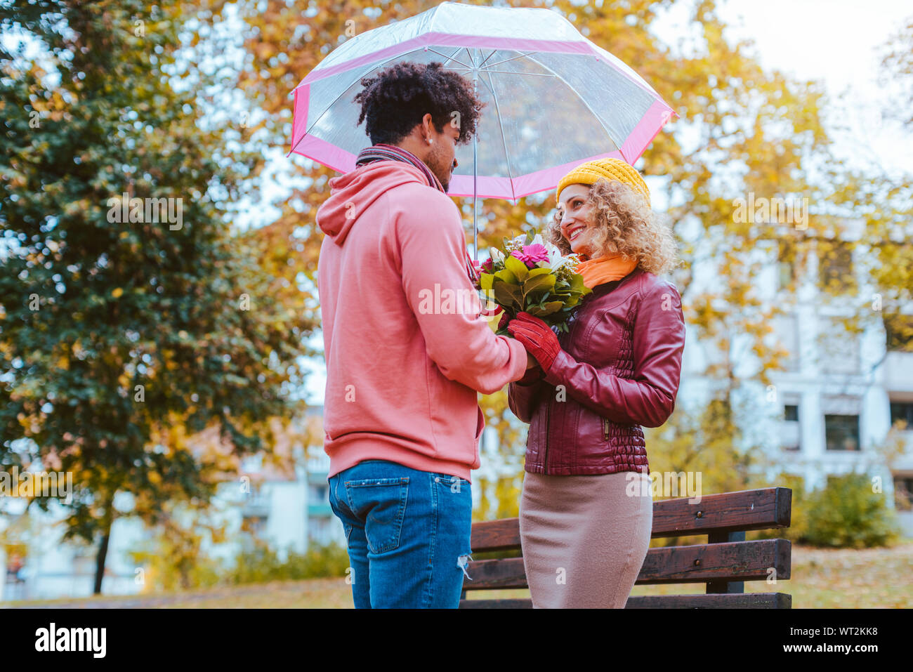 Schwarzer Mann Blumen zu seinen Kaukasischen Freundin im Herbst Stockfoto