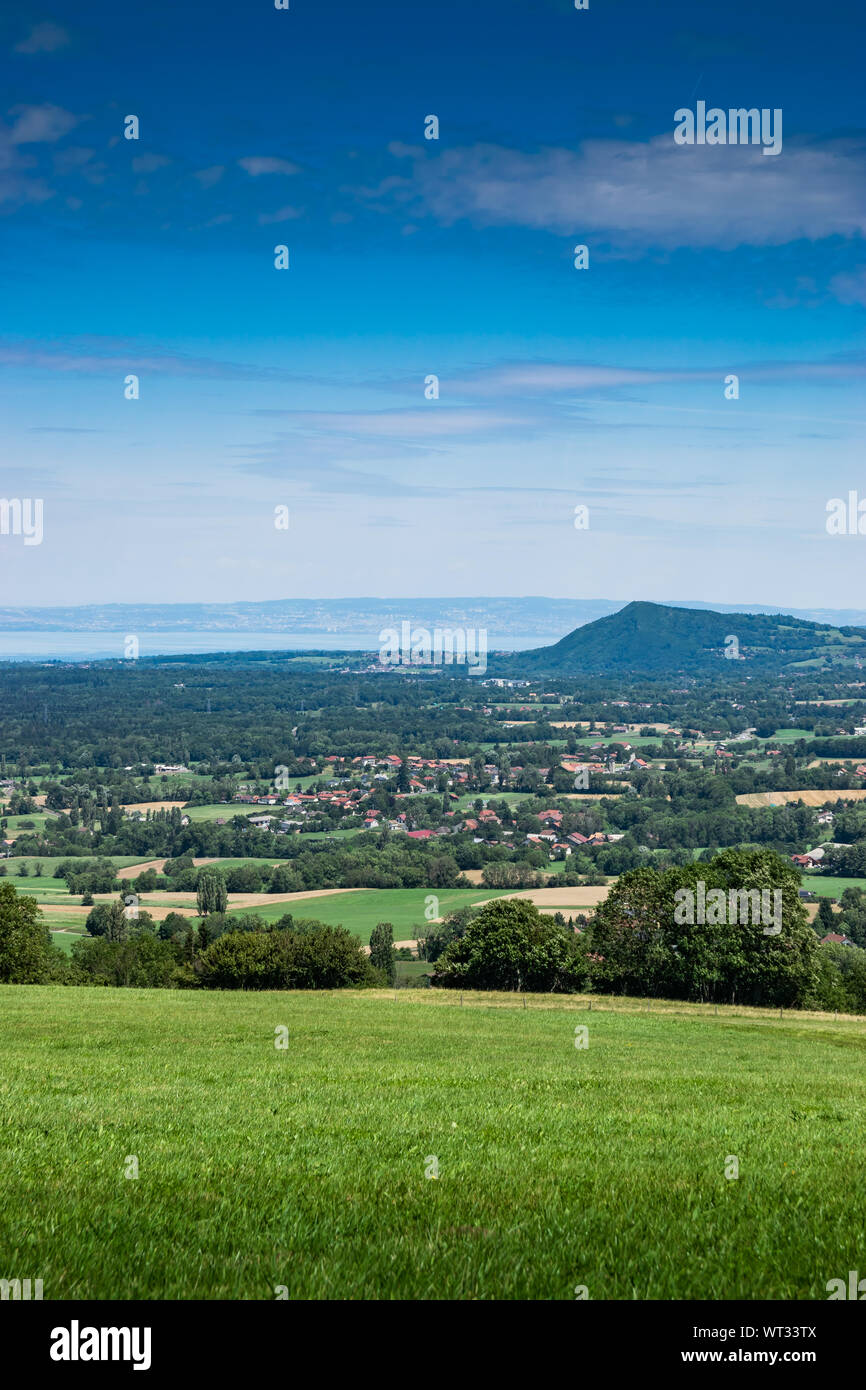 Stadt Landschaft in die Berge, Hügel, Felder, Wälder, grüne Wiesen, Seen in der Ferne und blauer Himmel mit Wolken. Haute-Savoie in Frankreich. Stockfoto