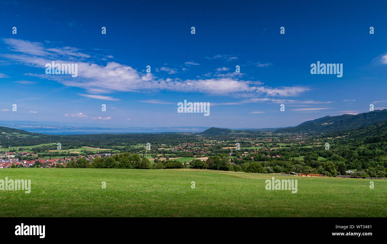 Stadt Landschaft in die Berge, Hügel, Felder, Wälder, grüne Wiesen, Seen in der Ferne und blauer Himmel mit Wolken. Haute-Savoie in Frankreich. Stockfoto