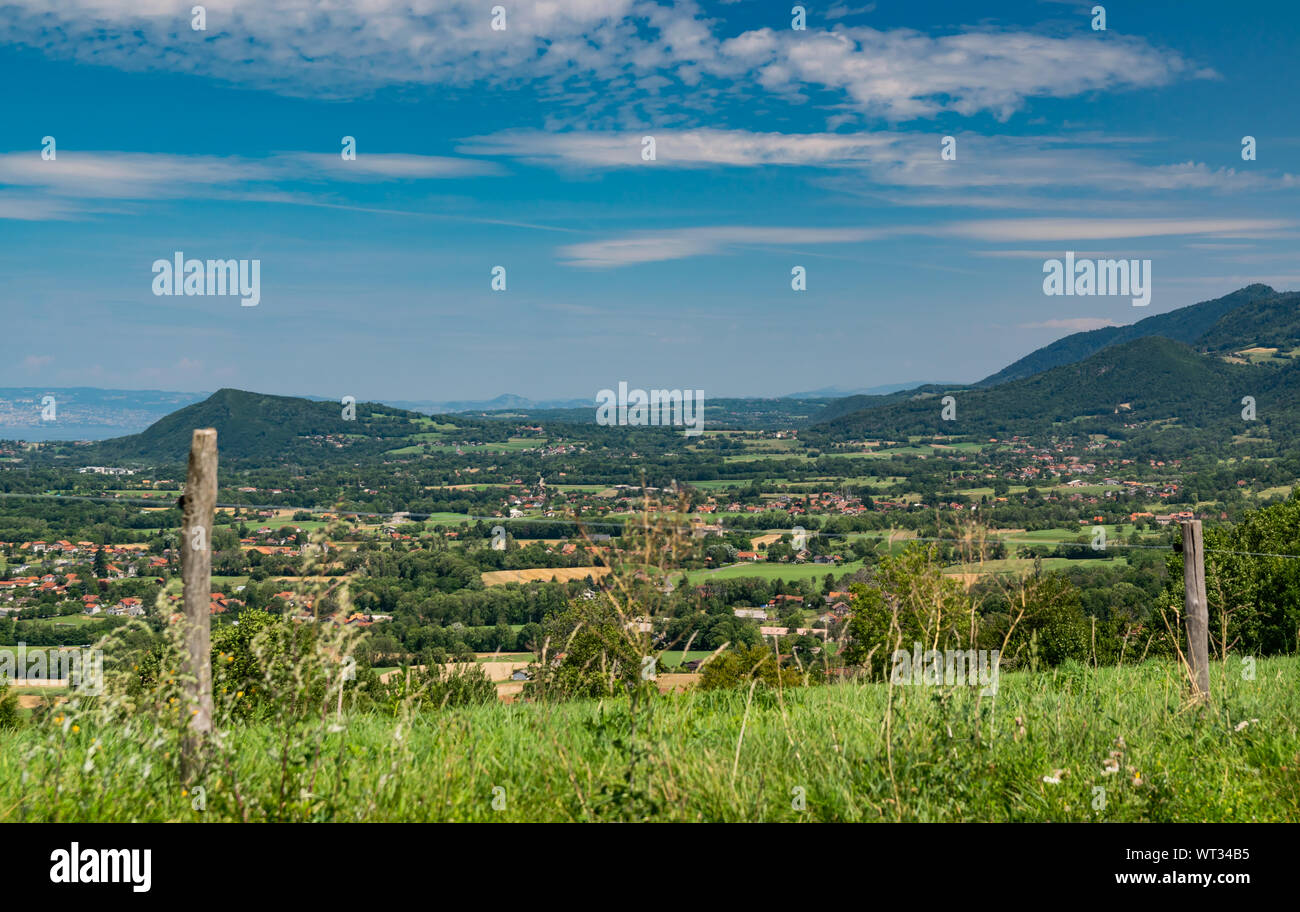 Stadt Landschaft in die Berge, Hügel, Felder, Wälder, grüne Wiesen, Seen in der Ferne und blauer Himmel mit Wolken. Haute-Savoie in Frankreich. Stockfoto