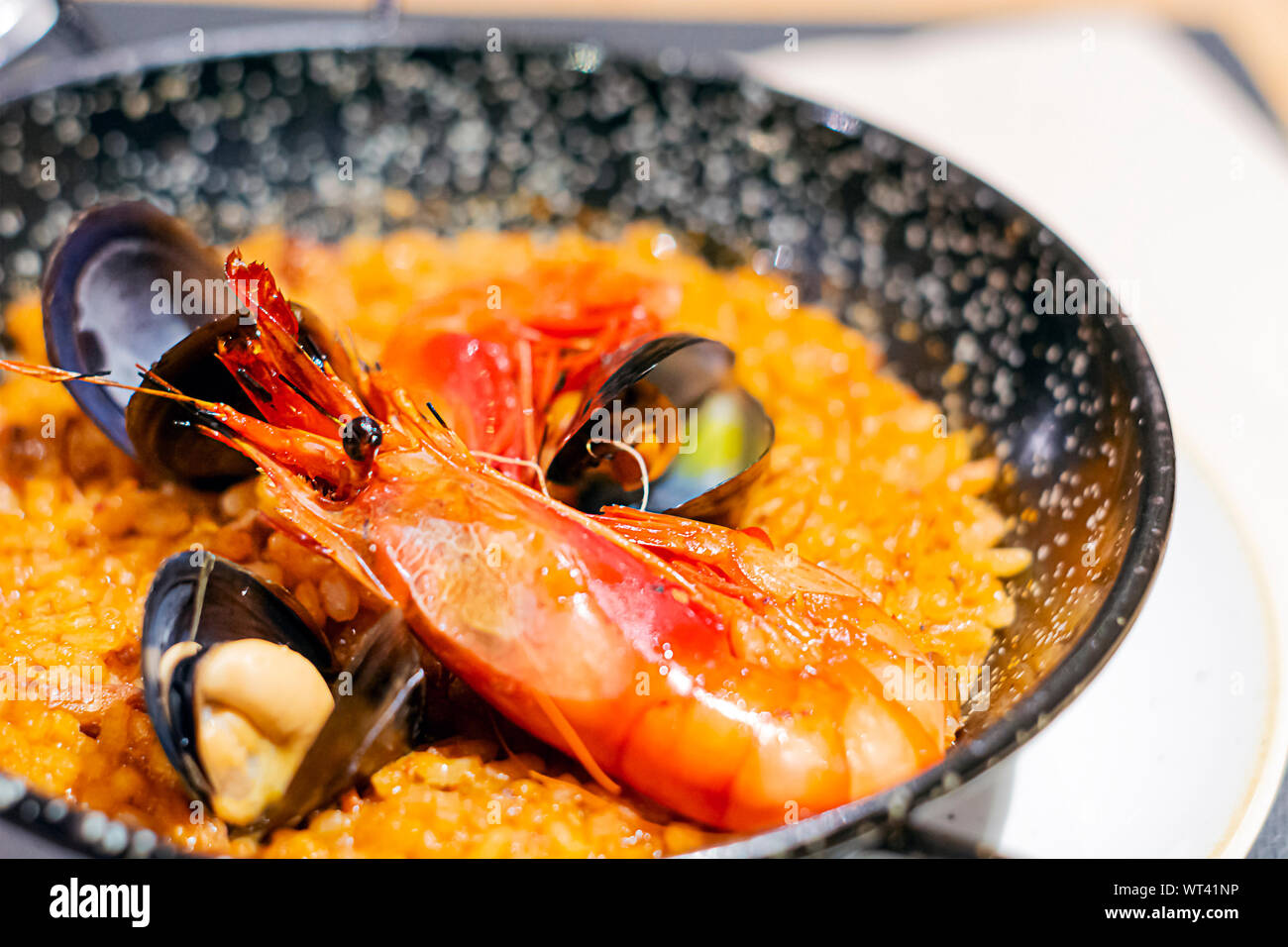 Valencianische Paella mit Reis, Safran und Meeresfrüchte in einer speziellen Pfanne serviert. Typisches Rezept der spanischen Küche. Stockfoto