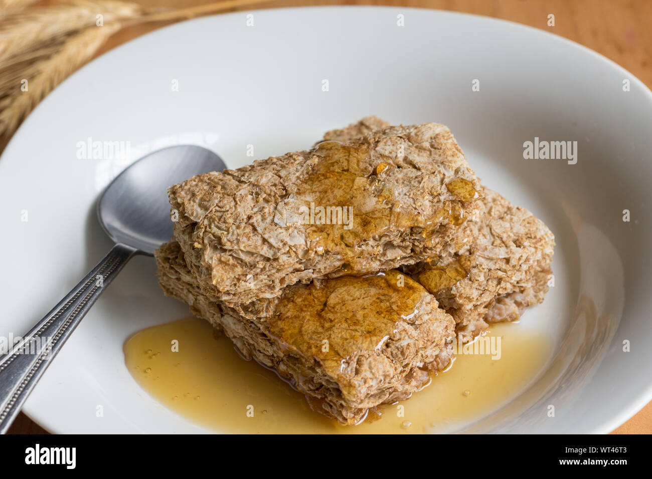 Frühstück Weizen Müsliriegel, beschichtet mit Honig in weiße Schüssel Nahaufnahme Stockfoto
