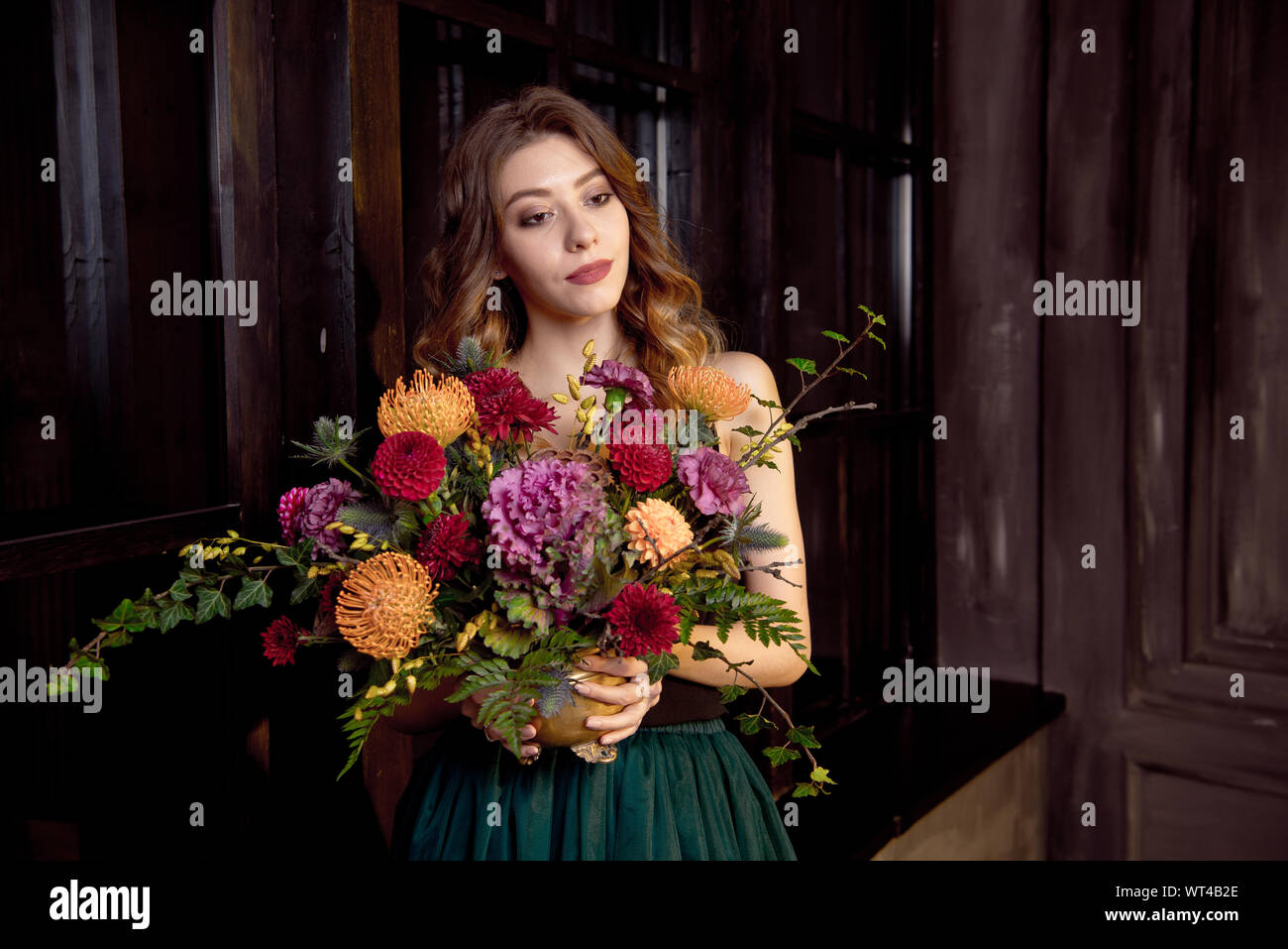 Halloween Party girl. Happy Halloween schöne Mädchen in einem schwarzen Top und Rock in ihren Händen hält einen Blumenstrauß mit Herbst Blumen. Stockfoto