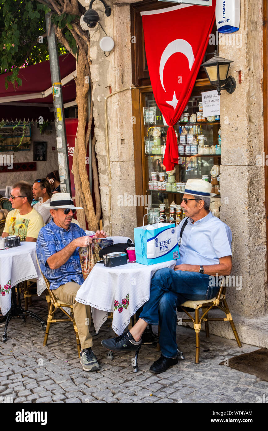 Alacati, Türkei - 4. September 2019: Männer in Hüte saß in einem Café. Die Stadt ist ein beliebtes Ziel für Touristen. Stockfoto