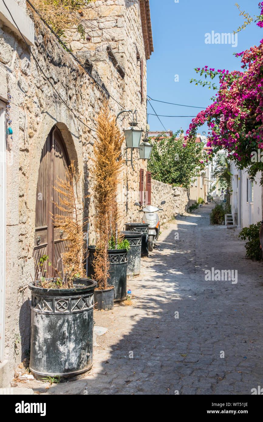 Schmale Straße mit Häusern aus Stein und Bougainvilleas, Alacati, Izmir, Türkei Stockfoto