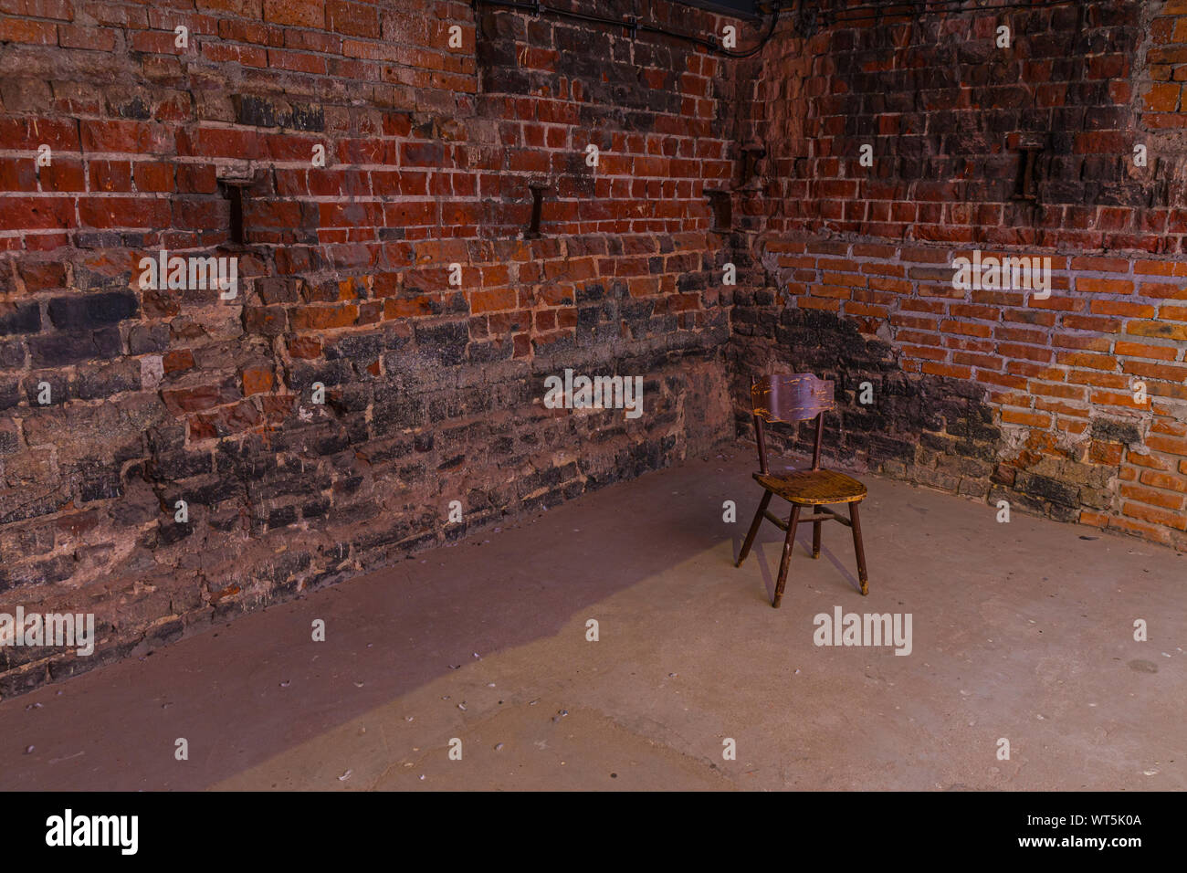 Einzel-, alten Stuhl gegen alte Mauer Stockfoto