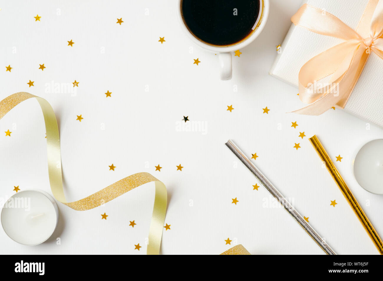 Ansicht von oben feminine Schreibtisch mit Kaffeetasse und Zubehör von Drittanbietern: ribbon, trinken Stroh, Geschenkbox, Kerzen auf weißem Hintergrund. Urlaub, Hochzeit feiern. Stockfoto