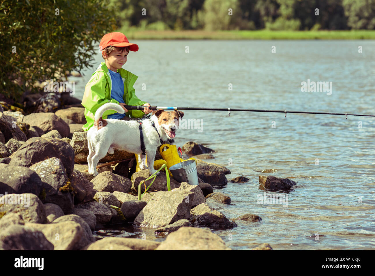 Spaß für die ganze Familie gemeinsam Konzept mit kleinen Jungen und dem Hund Angeln am Ufer des Sees Stockfoto