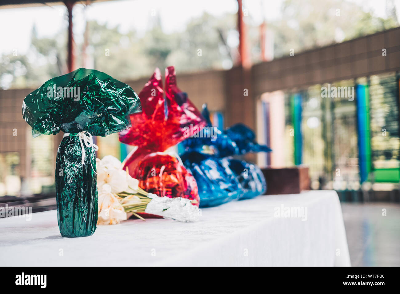 Lebensmittel und andere Lebensmittel in Grün, Rot und Blau Wasser cellophanes und Blume bereit auf dem Tisch für die gabenbereitung während der Eucharistie Stockfoto